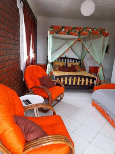 a room with two beds and orange chairs in it at Avamada Lodge in Ivato