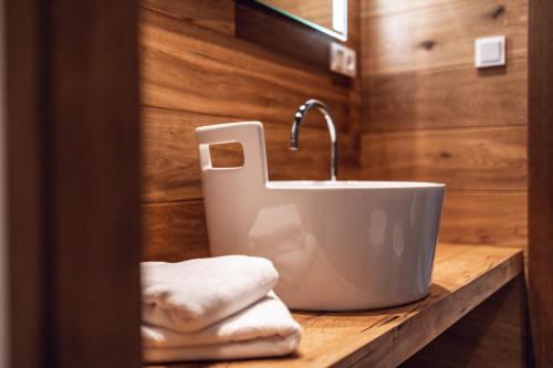 um lavatório de casa de banho com torneira e toalhas num balcão em Loom em Bolzano