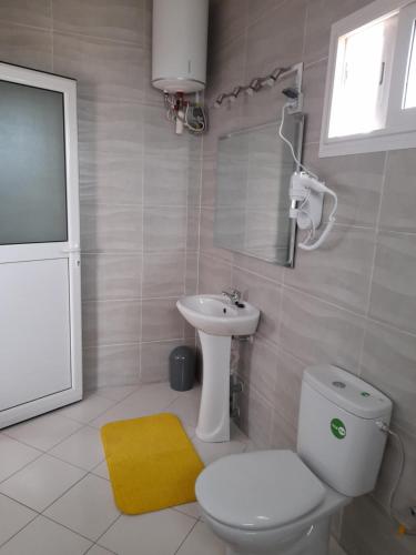 a bathroom with a white toilet and a sink at Avamada Lodge in Ivato