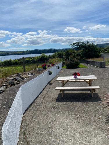 a wooden picnic table sitting next to a retaining wall at Eileen's House in Cork