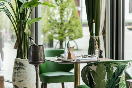 a table and chair in a room with plants at Varbergs Stadshotell & Asia Spa in Varberg