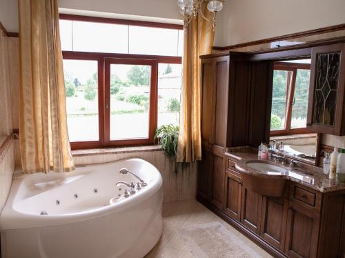 a large bathroom with a tub and a sink at Villa Avoti in Sigulda