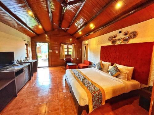a bedroom with a large bed and a kitchen at Beira Mar Beach Resort in Benaulim