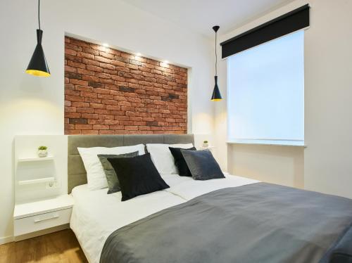 a bedroom with a large bed with a brick wall at Bed of Roses APT 1, Luxury, Designer decorated in Zagreb