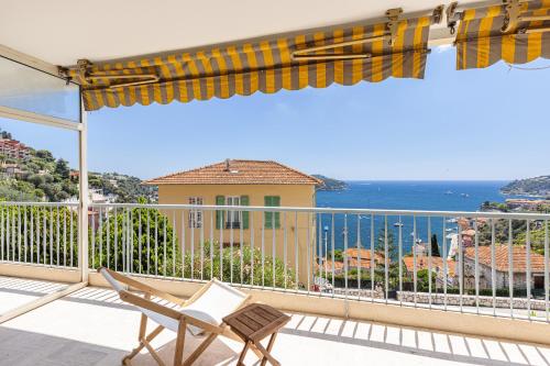 a balcony with a chair and a view of the ocean at Amazing Sea View 2Bdr Swimming Pool Parking in Villefranche-sur-Mer