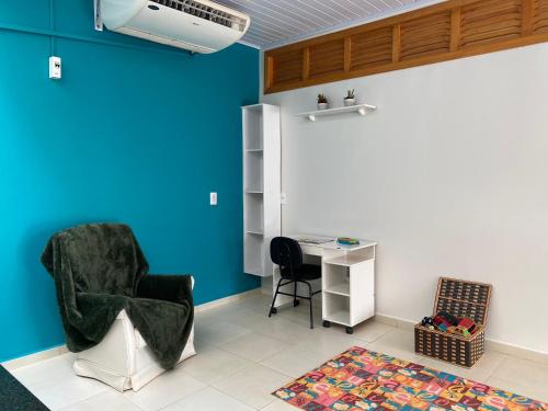 Cette chambre dispose d'un bureau, d'une chaise et d'un mur bleu. dans l'établissement Casa para alérgicos, crianças, idosos e Pets., à Foz do Iguaçu