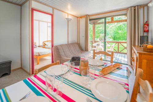 comedor con mesa y sala de estar en Les Chalets de Booz en Saint-Germain-du-Teil