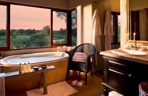 un ampio bagno con vasca e lavandino di Lion Sands - Tinga Lodge a Skukuza
