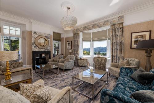 a living room with couches and a fireplace at Windermere Hillthwaite Hotel in Windermere
