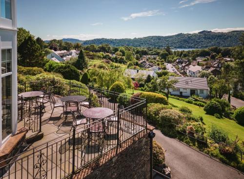 a balcony with tables and chairs overlooking a city at Windermere Hillthwaite Hotel in Windermere