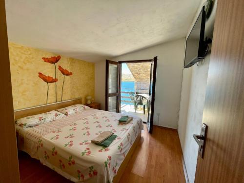 a bedroom with a bed and a view of the ocean at Apartments Dražica 4 in Zubovići