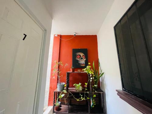 a hallway with a red wall with a skull on the wall at Calaveritas Rooms in Playa del Carmen