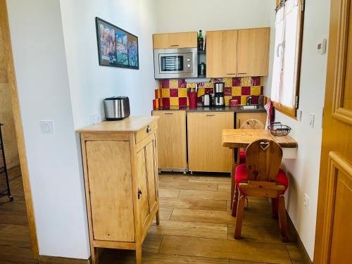 Il comprend une petite cuisine avec une table en bois et une petite table avec une chaise. dans l'établissement Chalet de Rozan, à La Tronche