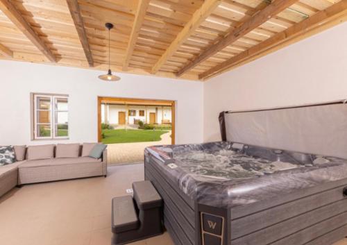 a large living room with a jacuzzi tub in the middle at Gyöngyike Vendégház - Szakály in Szakály