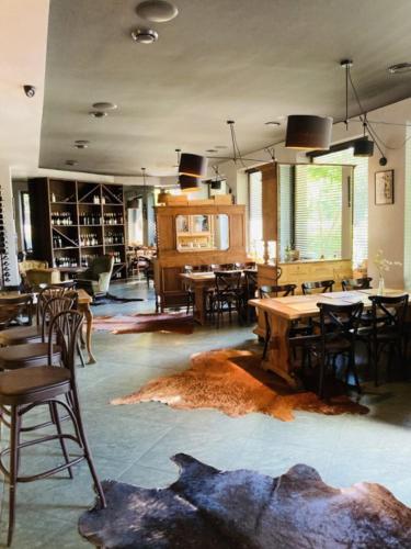 una sala da pranzo con tavoli e sedie e una stanza con tavoli di Willa Pastel a Białystok