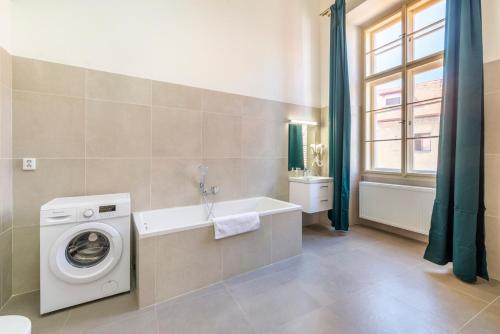 a bathroom with a washing machine and a tub at Celetná - Old Town Residence in Prague