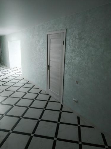 an empty room with a door and a tiled floor at Svitiaz Griada in Szack