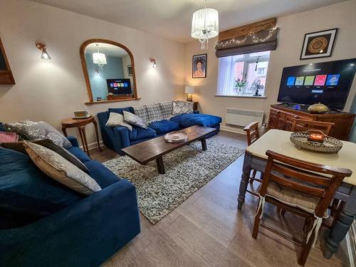 a living room with a blue couch and a table at Stunning Luxury Vintage Duplex with Parking in Manchester