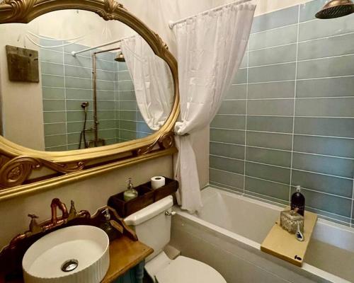 a bathroom with a sink and a mirror and a toilet at Stunning Luxury Vintage Duplex with Parking in Manchester