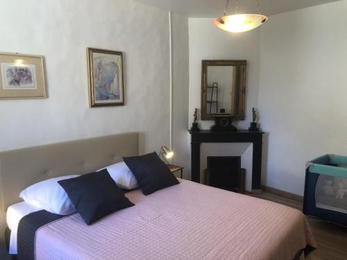 a bedroom with a bed with a fireplace and a mirror at Les Maisons du Conflent, maisons familiales en pierre au coeur des remparts in Villefranche-de-Conflent
