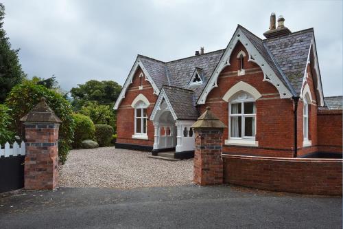 a red brick house with a gate in front of it at The Willows Lovely Double Apartment in Rostrevor
