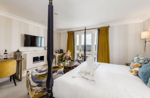 a bedroom with a bed and a living room at Windermere Hillthwaite Hotel in Windermere