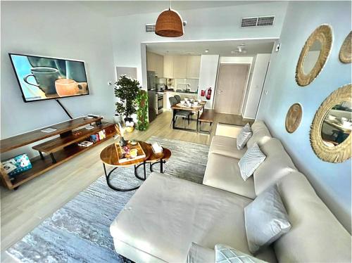 uma sala de estar com um sofá branco e uma mesa em Yas Island canal 1- Formula 1, Entertainment, and Luxury Living! em Abu Dhabi