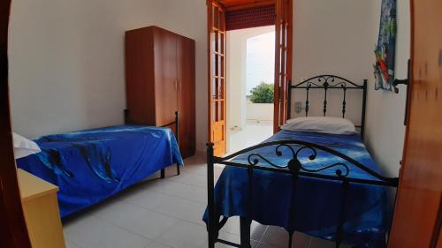 基諾沙的住宿－Appartamenti Alba e Tramonto，一间卧室配有两张蓝色床单