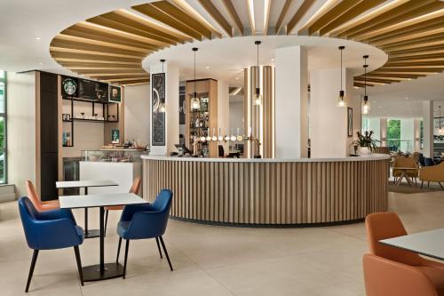 a lobby of a restaurant with tables and chairs at Holiday Inn Birmingham Airport - NEC by IHG in Bickenhill
