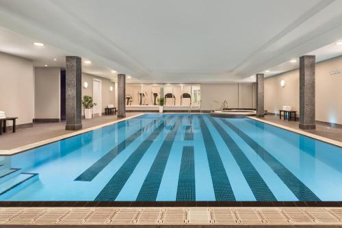 a large swimming pool with blue water in a building at Holiday Inn Birmingham Airport - NEC by IHG in Bickenhill