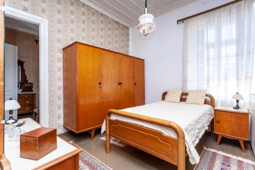 1 dormitorio con 1 cama y armario de madera en SOTIRIA, en Pythagoreio