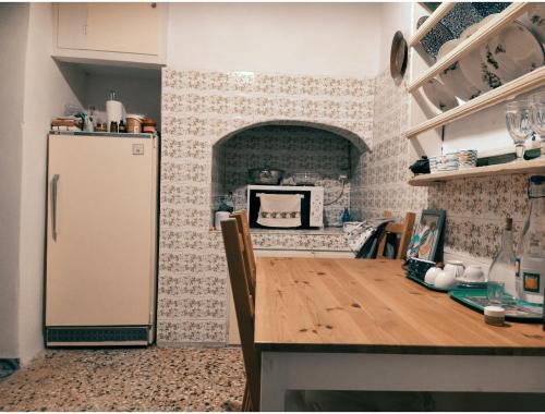 a kitchen with a refrigerator and a table in it at stone house in Kathlikaros in Mési