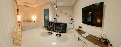 a large room with a bed and a television on a wall at Flat Noronha Dreams in Fernando de Noronha