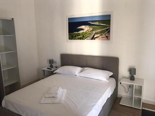 ein Schlafzimmer mit einem Bett mit einem Bild an der Wand in der Unterkunft LecceMareSalento in Lecce