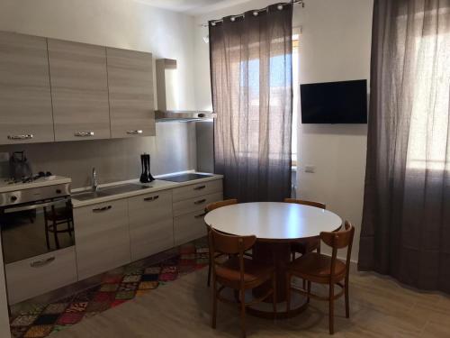 eine Küche mit einem Tisch, Stühlen und einem Waschbecken in der Unterkunft LecceMareSalento in Lecce