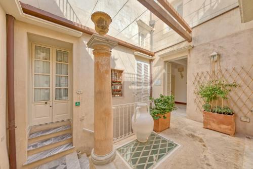 a hallway of a house with a vase on the floor at Palazzo Mosco Inn - Dimora Storica in Gallipoli