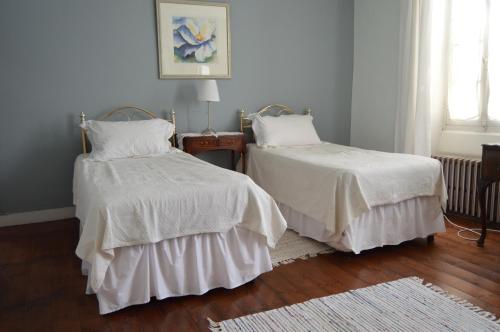 um quarto com 2 camas com edredões brancos em La Vieille Distillerie em Le Tâtre