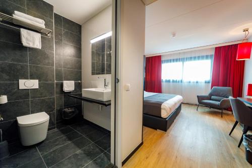 ナイメーヘンにあるBastion Hotel Nijmegenのベッドとバスルーム付きのホテルルームです。