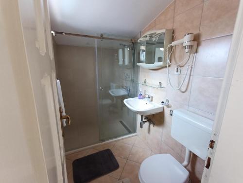 La salle de bains est pourvue d'une douche, de toilettes et d'un lavabo. dans l'établissement Guesthouse Moreta, à Vodice