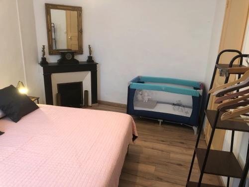 a bedroom with a bed and a mirror and a chair at Les Maisons du Conflent, maisons familiales en pierre au coeur des remparts in Villefranche-de-Conflent