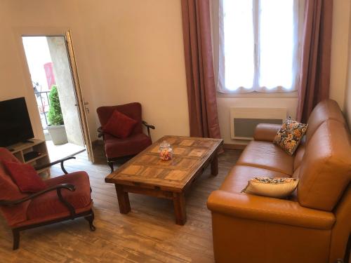 a living room with a couch and a table and chairs at Les Maisons du Conflent, maisons familiales en pierre au coeur des remparts in Villefranche-de-Conflent