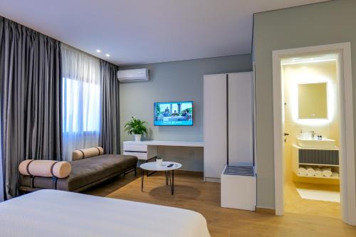 a hotel room with a bed and a couch at Sky Way SKK Luxury Apartments in Sarandë