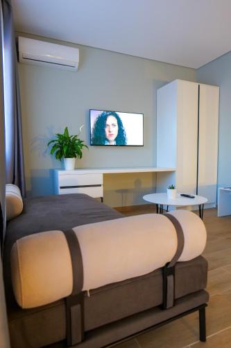 a bedroom with a bed and a tv on the wall at Sky Way SKK Luxury Apartments in Sarandë