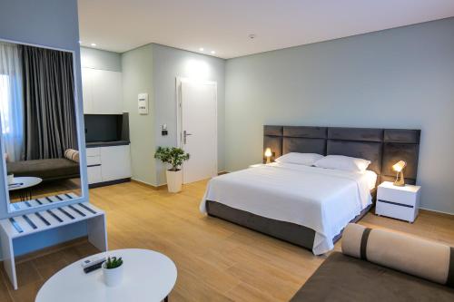 Sky Way SKK Luxury Apartments في سارنده: غرفة نوم بسرير كبير وغرفة معيشة