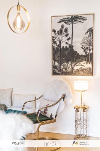 a living room with a chair and a picture on the wall at Appartement VILLA PAULA Ax-les-Thermes in Ax-les-Thermes
