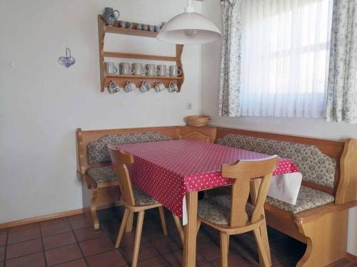 a dining room table and chairs with a red table cloth at Ferienhaus Meineke in Regen