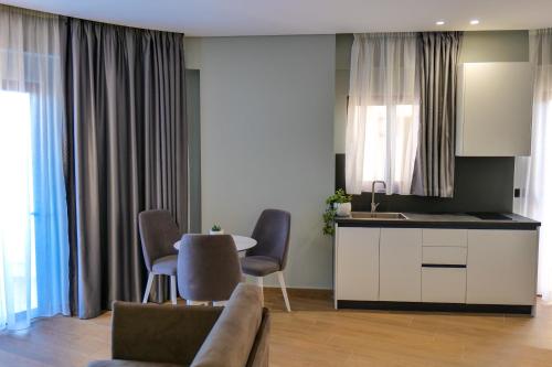 a kitchen and a living room with a table and chairs at Sky Way SKK Luxury Apartments in Sarandë