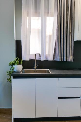 a kitchen counter with a sink and a window at Sky Way SKK Luxury Apartments in Sarandë