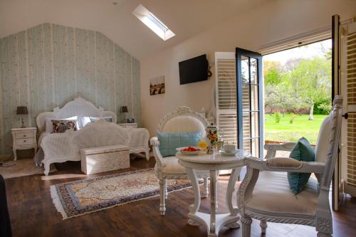 a living room with white chairs and a table at Clonganny House in Ballygarrett