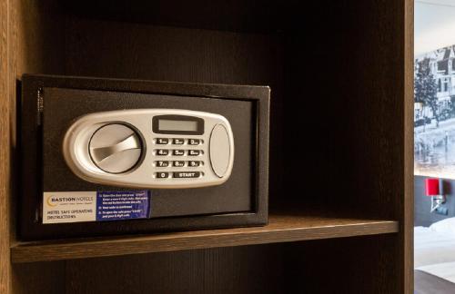 a remote control sitting on top of a shelf at Bastion Hotel Nijmegen in Nijmegen